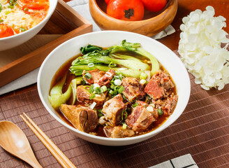 Beef Noodle Soup with Tender Braised Beef in bowl isolated on table side view of taiwan food