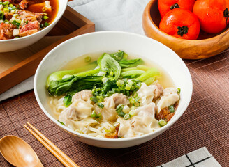 Wenzhou wonton noodles soup with green onion in bowl isolated on napkin side view on table taiwan food