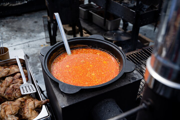 In the kitchen, there is a pot filled with a delicious soup, and resting inside it is a shiny spoon, ready to serve up portions of warmth and nourishment to those who enjoy it