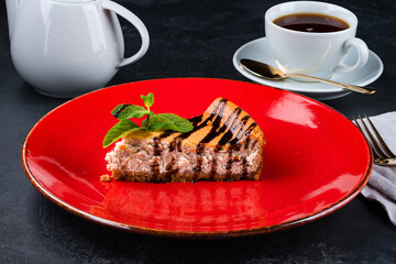 Slice of cheesecake with chocolate sauce and mint.