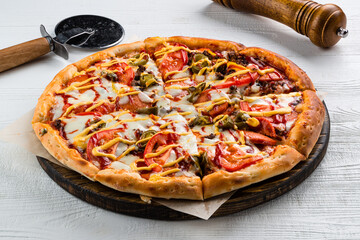 Italian pizza with sausages, jalapeno pepper, mozzarella, tomatoes and sauce.