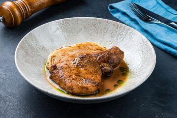 Dinner fried pork fillet steak with baked cabbage and sauce.