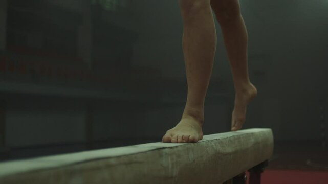 Legs of a Gymnast in red practicing on balance beam