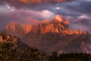Fototapeta premium Romantic colorful sunrise in the mountains on the border between Slovenia, Austria and Italy. Breathtaking moment when the sun paint colors across the whole sky and into the clouds.