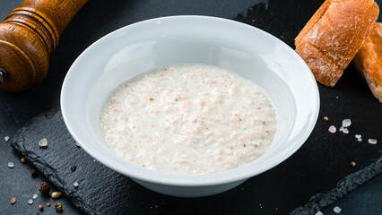 Garnish boiled oatmeal porridge with milk in a plate.
