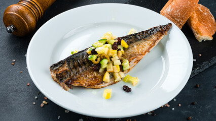Lunch fried fish with cucumbers, apple, raisins and olives.