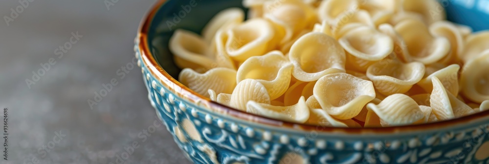 Canvas Prints Orecchiette pasta made from durum wheat and water displayed in an attractive blue bowl, showcasing a traditional delicacy.