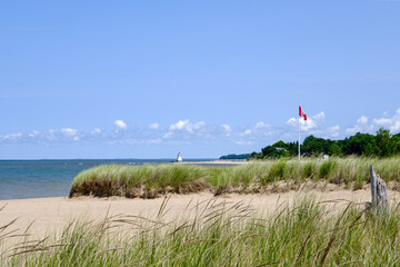 Sandy shores beach in the summer lighthouse at distance