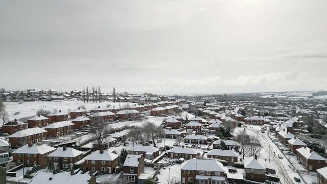 Aerial Drone Video Footage showing a snowy landscape in a suburban UK town.