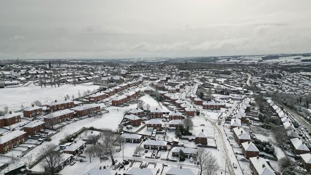 Aerial Drone Video Footage showing a snowy landscape in a suburban UK town.