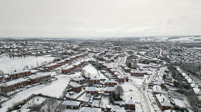 Aerial Drone Video Footage showing a snowy landscape in a suburban UK town.