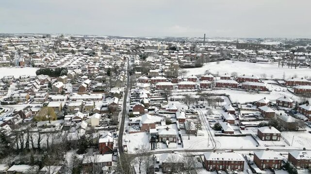 Aerial Drone Video Footage showing a snowy landscape in a suburban UK town.
