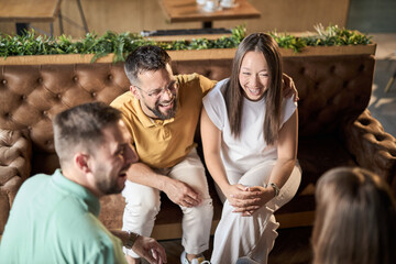 Happy  couple enjoying in conversation with their  friends during a social gathering in a cafe