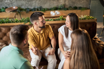 Happy  couple enjoying in conversation with their  friends during a social gathering in a cafe