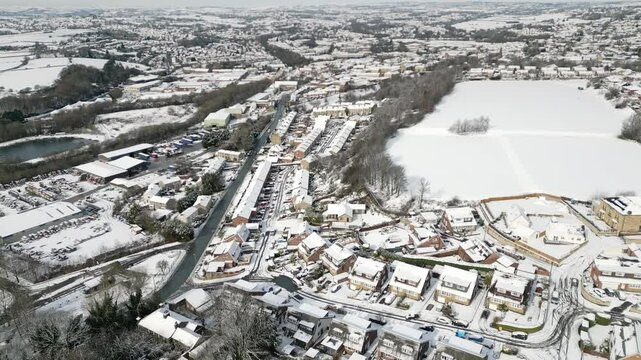 Aerial Drone Video Footage showing a snowy landscape in a suburban UK town.