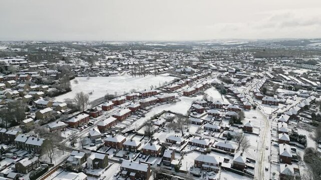 Aerial Drone Video Footage showing a snowy landscape in a suburban UK town.