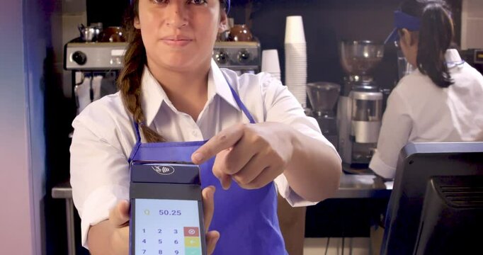 Cashier offers her customer an electronic method to pay with their credit card.