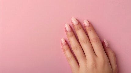 A hand elegantly displays a gradient manicure in soft pink hues, set against a simple pink background. This design highlights modern nail art trends