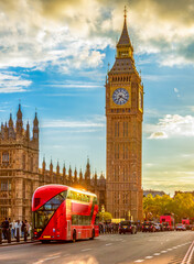 Double-decker bus on Westminster bridge and Big Ben tower at sunset, London, UK