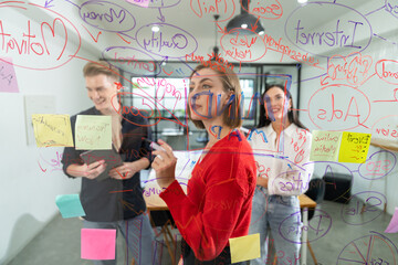 Creative business team brainstorming discussing and sharing marketing idea about start up project by using mind map colorful sticky note at glass board meeting room. Working together. Immaculate.
