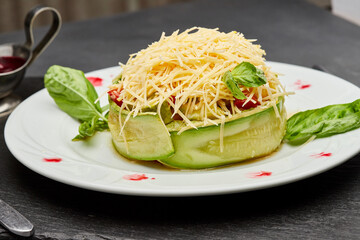 Fresh zucchini salad with parmesan cheese, basil leaves, and berry sauce on a gourmet plate