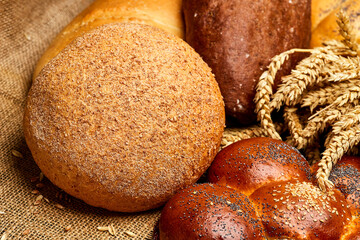 Assortment of freshly baked bread loaves with wheat stalks, tradition and artisanal baking
