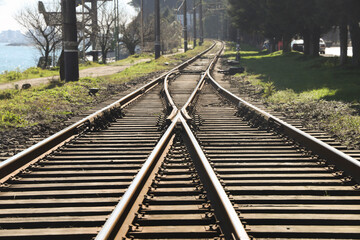 Railway station junctions. 2 Two railway tracks merge together. Rail way track along Black Sea with...