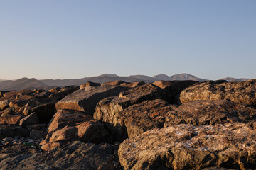 Obraz premium brown mountain range silhouettes. yellow panoramic landscape view. caucasian Mountain ridges and hills background. shade mount peaks. scenery terrain. Batumi Adjara Georgia. sunset light. evening time
