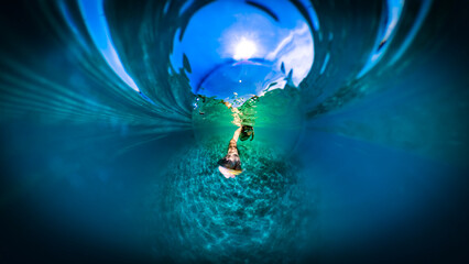 Underwater photo of man diving in the dark, blue Adriatic sea at the town of Rogoznica, Croatia