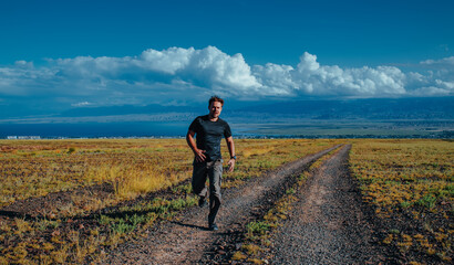 Young man tourist running in the mountains on beautiful landscape