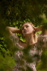A Beautiful and Elegant Young Woman in a Lovely Summer Dress Posing Gracefully Outdoors