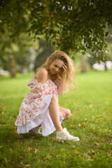 Obraz premium A Beautiful and Elegant Young Woman in a Lovely Summer Dress Posing Gracefully Outdoors