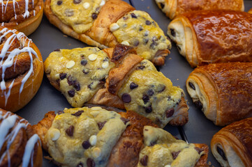 Fresh baked buttered croissants and sweet buns, pastries in village bakery in France