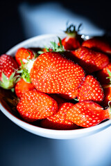 Plate with french organic red ripe sweet strawberries Fraises de Plougastel, harvested in France