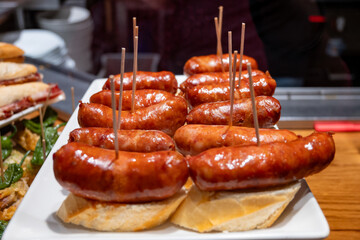 Typical snacks of Basque Country, pinchos or pinxtos skewers with small pieces of bread, fish, sea food, sweet green pepper served in bar in San-Sebastian or Bilbao, Spain