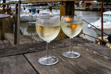 Tasting of Bordeaux white wine, right bank of Gironde Estuary, France. Glasses of white sweet French wine served in outdoor restaurant on oysters farm in Gujan-Mestras, Arcachon bay
