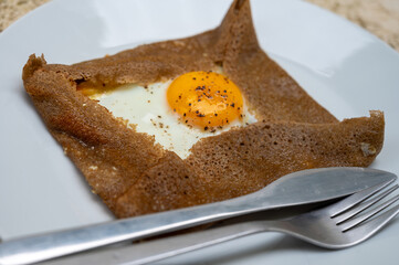 Galettes pancakes from Brittany made with buckwheat flour and served with savoury toppings, smelted cheese and eggs