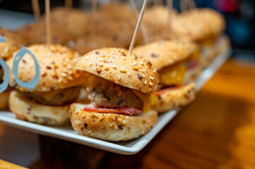 Typical snacks of Basque Country, pinchos or pinxtos skewers with small pieces of bread, fish, sea food, sweet green pepper served in bar in San-Sebastian or Bilbao, Spain