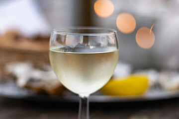 Tasting of Bordeaux white wine, right bank of Gironde Estuary, France. Glasses of white sweet French wine served in outdoor restaurant