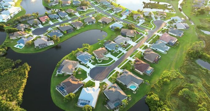 Upscale suburban homes at sunset with large backyards and green grassy lawns. Private residential houses in rural suburban sprawl area in Sarasota, Florida