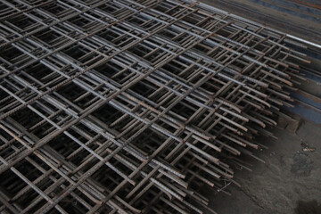 Close-up of stacked steel rebar grids, essential for reinforcing concrete in construction projects. Ideal for illustrating industrial and architectural concepts