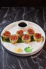 Delicious Sushi Rolls with Fresh and Colorful Toppings Accompanied by a Dipping Sauce