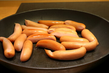 Prince sausages in a frying pan. Traditional Swedish Christmas food. Sweden in December.