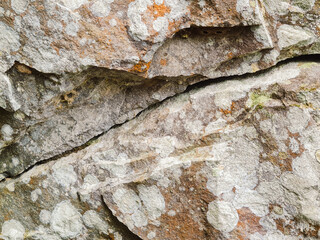 close up vief of detailed crack at rock stone with some white mold stain, grunge textured pattern image.