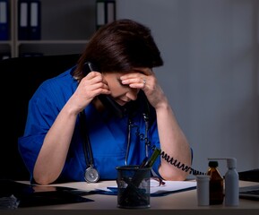 Aged female doctor working at night shift
