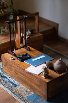 Mesa ordenada para escritura japonesa con tetera, brochas y tinta