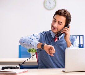 Young handsome employee working in the office