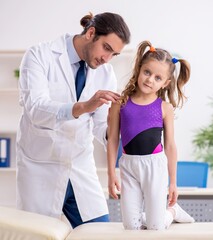 Small girl visiting young male doctor