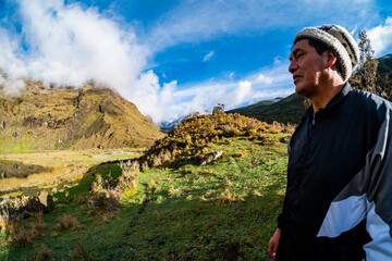 portrait of an elderly Andean man, with a depressed look in the background of the Andes mountains