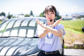 車の営業マンがNGサインをする
A car salesman makes a 